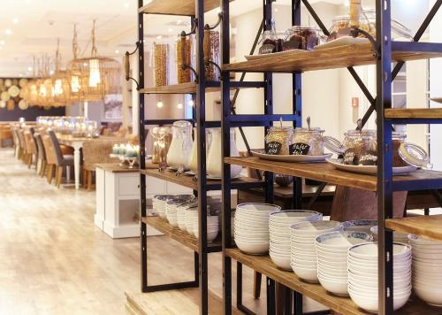 una tienda con estantes llenos de platos y cuencos en Beach Motel Heiligenhafen, en Heiligenhafen