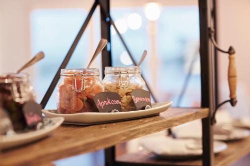 una mesa con tarros de comida en un estante en Beach Motel Heiligenhafen, en Heiligenhafen