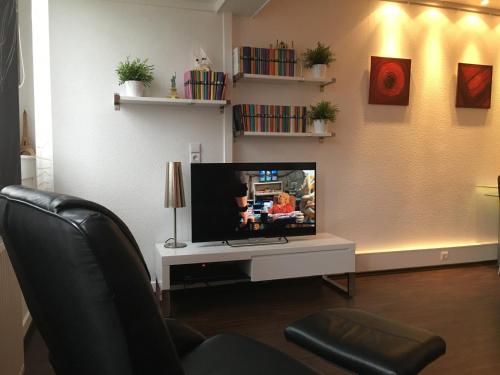 a living room with a television on a white table at Fewo Brasilia247 in Schönberg in Holstein