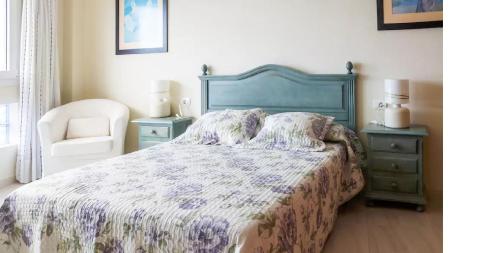 een slaapkamer met een groot bed en een stoel bij Crucero vista al mar A in Puertito de Güímar