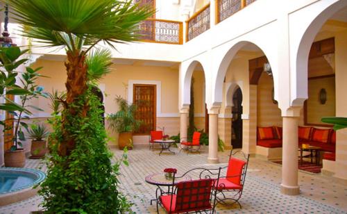 um pátio com cadeiras e uma mesa num edifício em Riad Rabahsadia em Marrakech