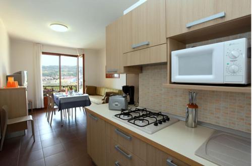 a kitchen with a stove top and a microwave at Residence Corte Camaldoli in Garda
