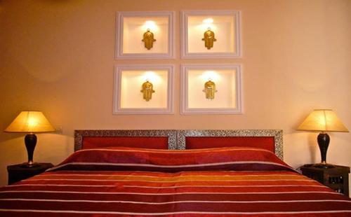 a bedroom with a bed with three pictures on the wall at Riad Rabahsadia in Marrakech