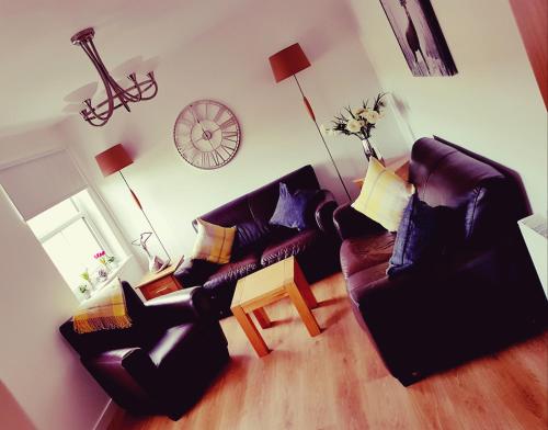 a living room with two couches and a table at Yvi's 2Bedroom 2Bathroom Apartment in Inverurie