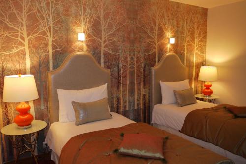 a hotel room with two beds and two lamps at Le Chapeau Rouge in Lusignan