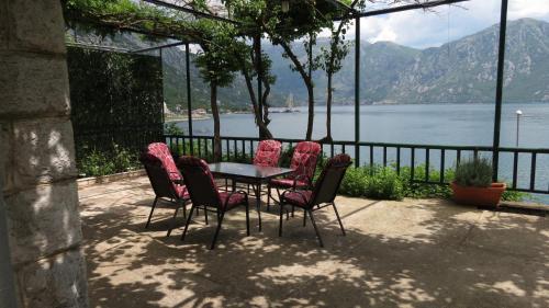 Una mesa y sillas con vista al agua. en Apartment Capt Seferovic, en Donji Morinj