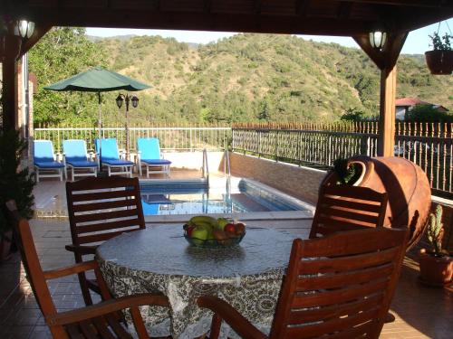 a table and chairs with a bowl of fruit on it at The Love Holiday House in Tris Elies