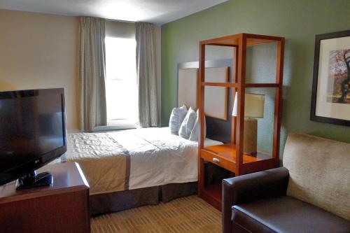 a hotel room with a bed and a flat screen tv at Extended Stay America Select Suites - Denver - Tech Center - Central in Greenwood Village