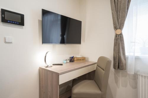 a room with a desk and a tv on a wall at Čajkovskij Apartments Brno-jih in Brno