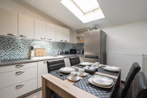 a kitchen with a table with chairs and a refrigerator at Čajkovskij Apartments Brno-jih in Brno