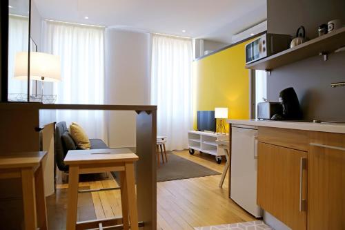 a kitchen and a living room with a table at Appartements Numeroa in Albi
