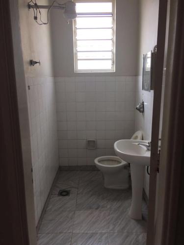 a bathroom with a toilet and a sink at Hotel São João in Campinas
