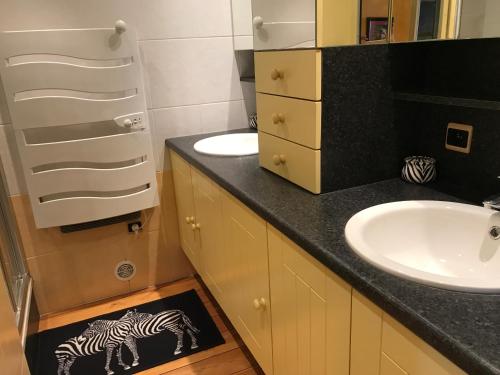 une salle de bain avec un lavabo et un tapis zèbre au sol dans l'établissement Luxe appartement Village Naturiste Zébra, au Cap d'Agde
