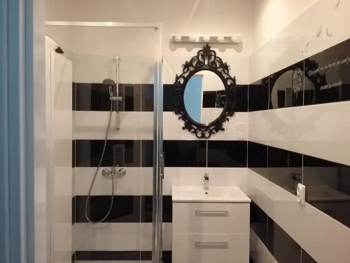 une salle de bain avec une douche, un lavabo et un miroir dans l'établissement Apartament Pod Wroną, à Toruń