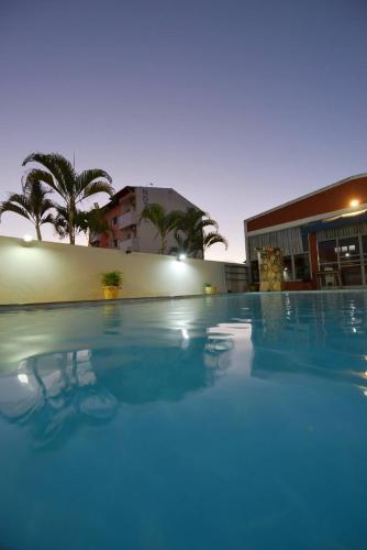 a large blue swimming pool in front of a building at Manhattan Hotel in Caldas Novas