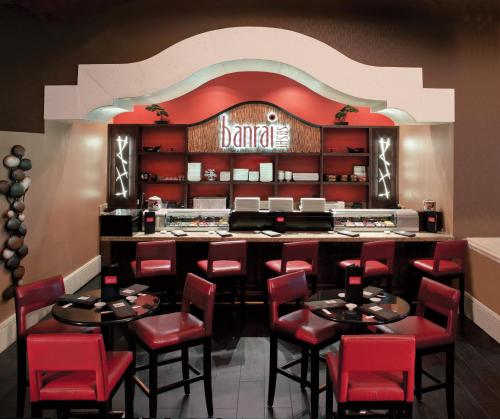 a restaurant with red chairs and a bar at Rosen Shingle Creek Universal Blvd in Orlando