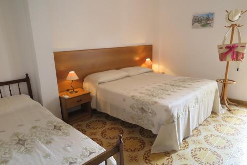 una camera con due letti e un tavolo con due lampade di Appartamento Petrarca a Gallipoli
