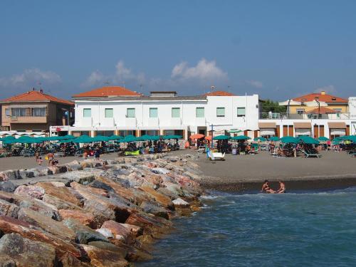 a group of people on a beach near the water at Hotel Aurora in Marina di Cecina