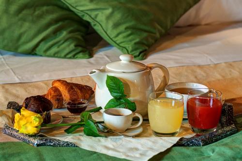 a tray with a tea pot and cups of coffee and bread at Il Giuncheto in Trequanda