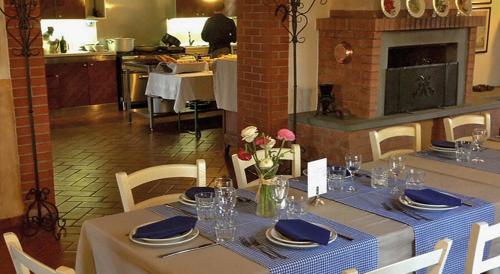 a dining table with a blue and white table cloth and flowers at Agriturismo Bassanella in Treviglio