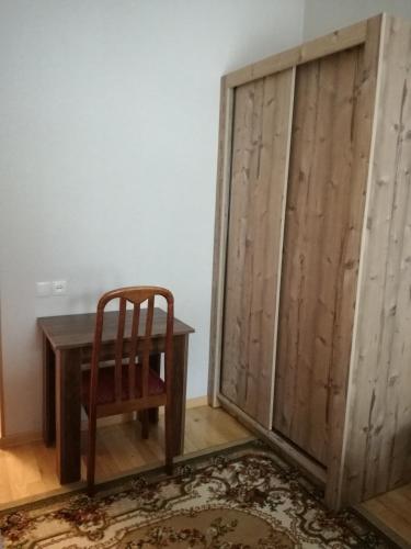 a wooden sliding door with a chair and a table at Light House Old City in Akhaltsikhe