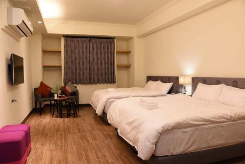 Habitación de hotel con 2 camas y mesa en Yun Dan, en Lugu