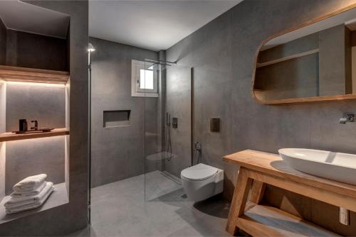 a bathroom with a shower and a toilet and a sink at Elia Mykonos Resort in Elia Beach