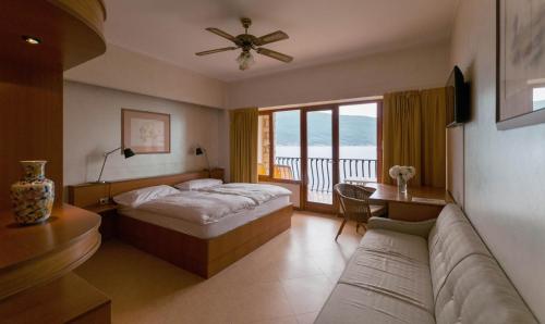 una camera d'albergo con letto e divano di Hotel Forbisicle a Tignale