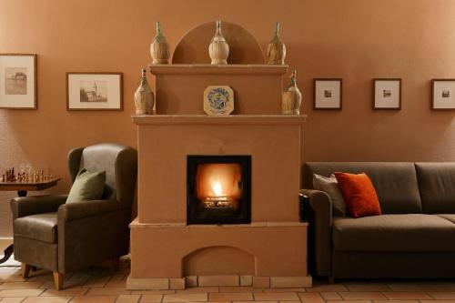 a fireplace in a living room with two couches and a fire at Relais Rossar Boutique Hotel Garda & Hills in Costermano sul Garda