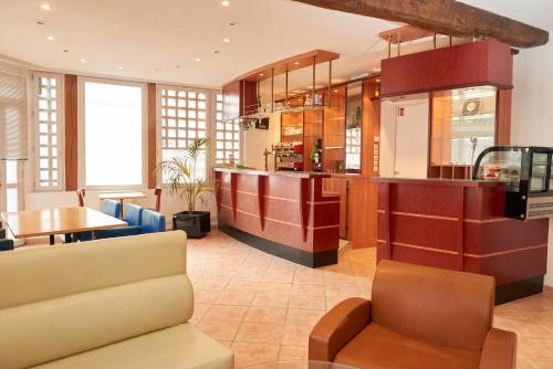 a large kitchen with a counter and a table at chambres d'hotes du colvert in Forges-les-Eaux