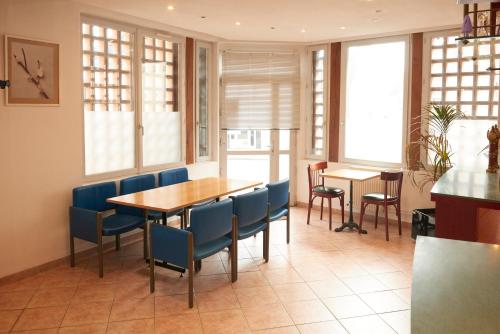 a dining room with a table and blue chairs at chambres d'hotes du colvert in Forges-les-Eaux