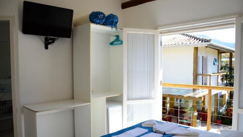 a room with a window and a tv and a bed at Pousada Cana Caiana in Paraty