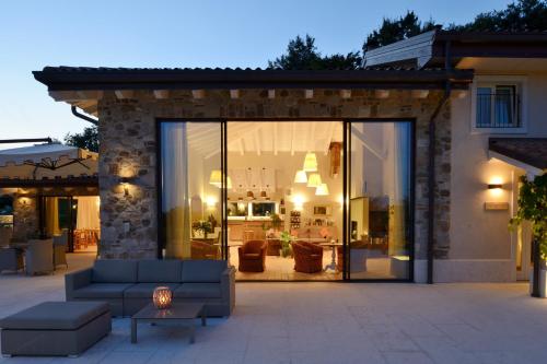 a living room with a couch in front of a building at Relais Rossar Boutique Hotel Garda & Hills in Costermano sul Garda