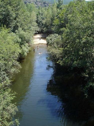 a view of a river with people swimming in it at El Rincón de Monasterio in Monasterio