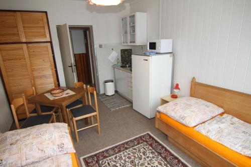 a small room with a bed and a table and a refrigerator at Chata Javorina in Javorník