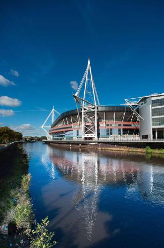 a stadium with a building and a body of water at Stunning Spacious City Apartment with free parking in Cardiff