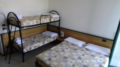 a room with two bunk beds and a chair at Hotel La Pergola in Moniga