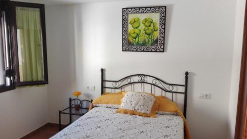 a bedroom with a bed and a picture on the wall at Casa El Pinsapar in El Bosque