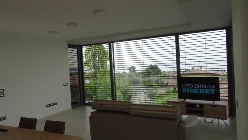 a living room with a couch and a large window at Hotel La Pergola in Moniga