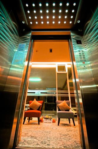 a room with two chairs and a table and a mirror at The Sila Hotel in Si Racha