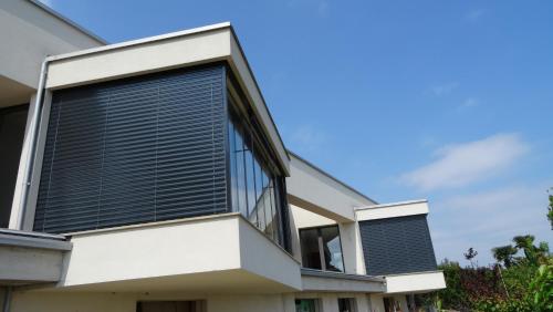 an external view of a house with black blinds at Hotel La Pergola in Moniga