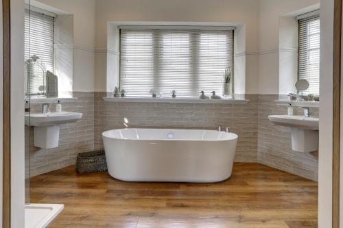 Falcon Manor Hotel في سيتل: حوض استحمام أبيض في حمام به مغسلتين