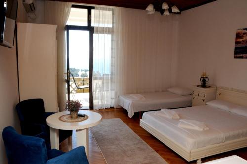 un soggiorno con 2 letti, un tavolo e una finestra di Guest House Smajlaga a Ulcinj