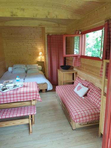 - une chambre avec 2 lits dans une cabane en rondins dans l'établissement Les etangs de planquery, à Planquery