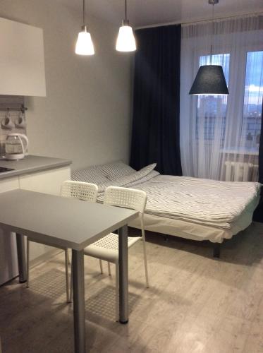 ヴォログダにあるApartment on Lavrova 9のベッドルーム1室(ベッド1台、テーブル、椅子付)