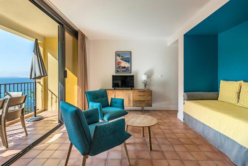 - un salon avec un lit et un balcon dans l'établissement La Résidence du Bailli, à Rayol-Canadel-sur-Mer