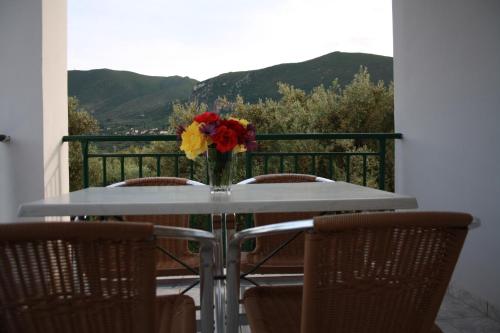a table with a vase of flowers on a balcony at Laura Beach House in Alykes