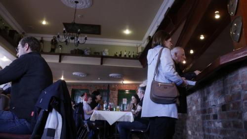 a woman standing at a bar in a restaurant at The Seaview Tavern in Ballygorman