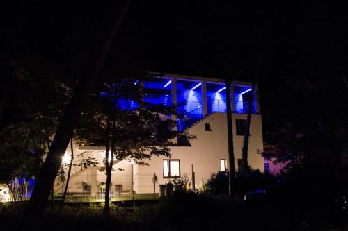 ユラタにあるAqua Marineの夜間の青い灯りが灯る建物