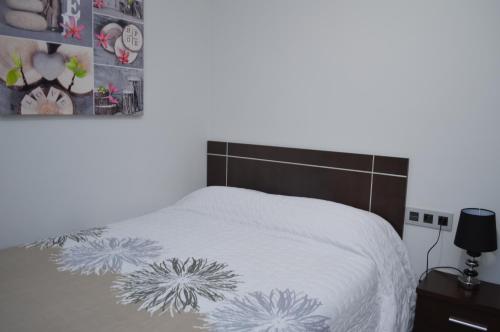 a bedroom with a bed with a white comforter at Apartamento Prado - Casa Eva in Ardales